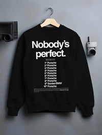 Black crewneck sweatshirt on a hanger against a grey wall, featuring Porsche rs racing le mans motorsport street graphic.