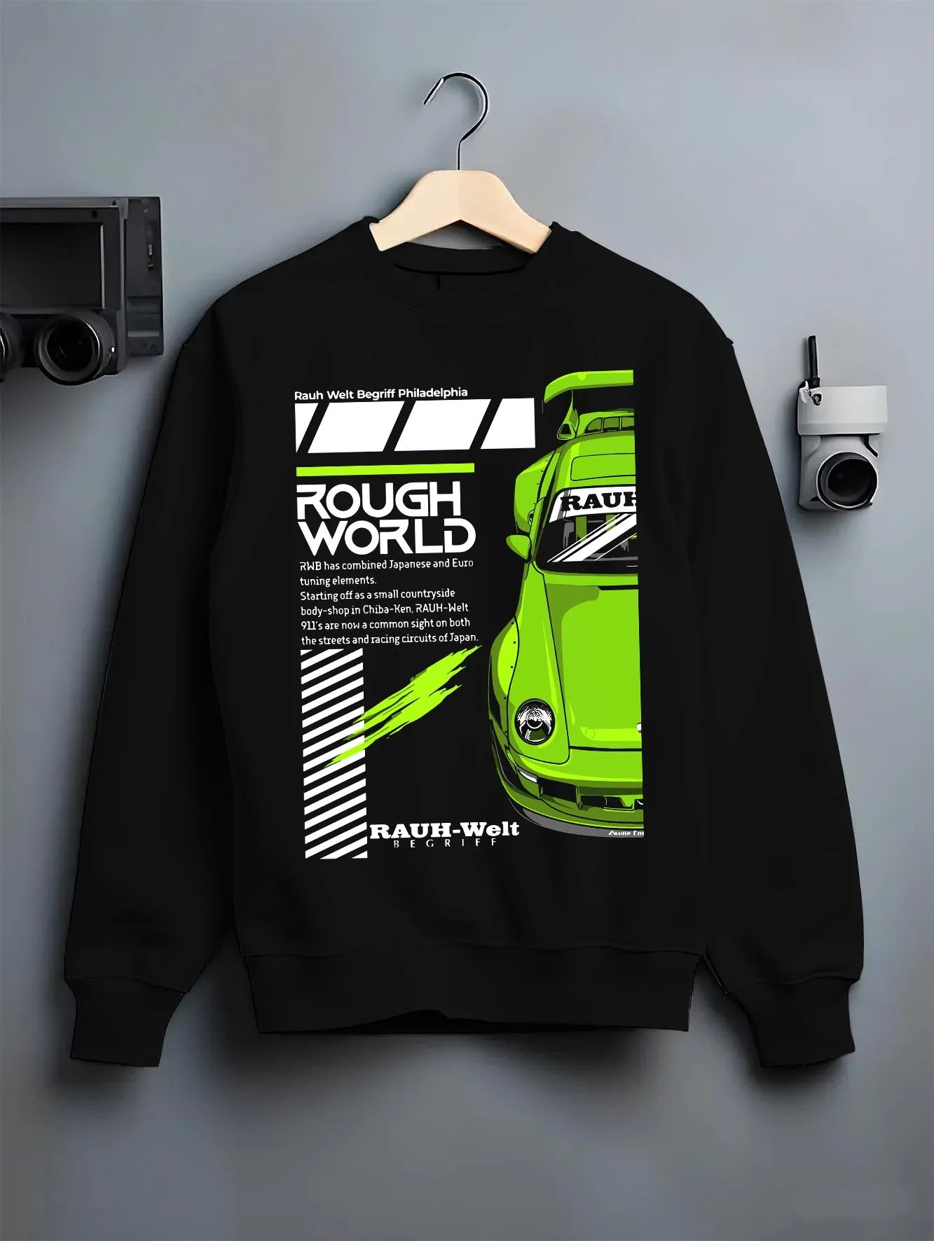 Black crewneck sweatshirt on a hanger against a grey wall, featuring Porsche rs japanese euro tuning stance rwb street graphic.