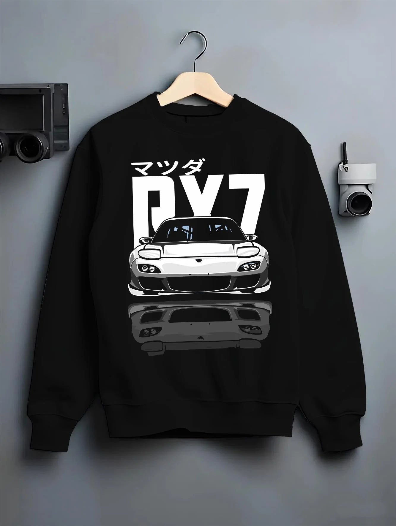 Black crewneck sweatshirt on a hanger against a grey wall, featuring Mazda RX-7 rx7 drift japanese tuner stance street graphic.