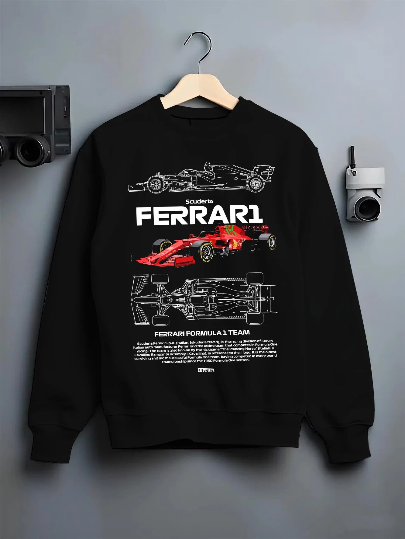 Black crewneck sweatshirt on a hanger against a grey wall, featuring Ferrari rs racing f1 formula motorsport legend graphic.