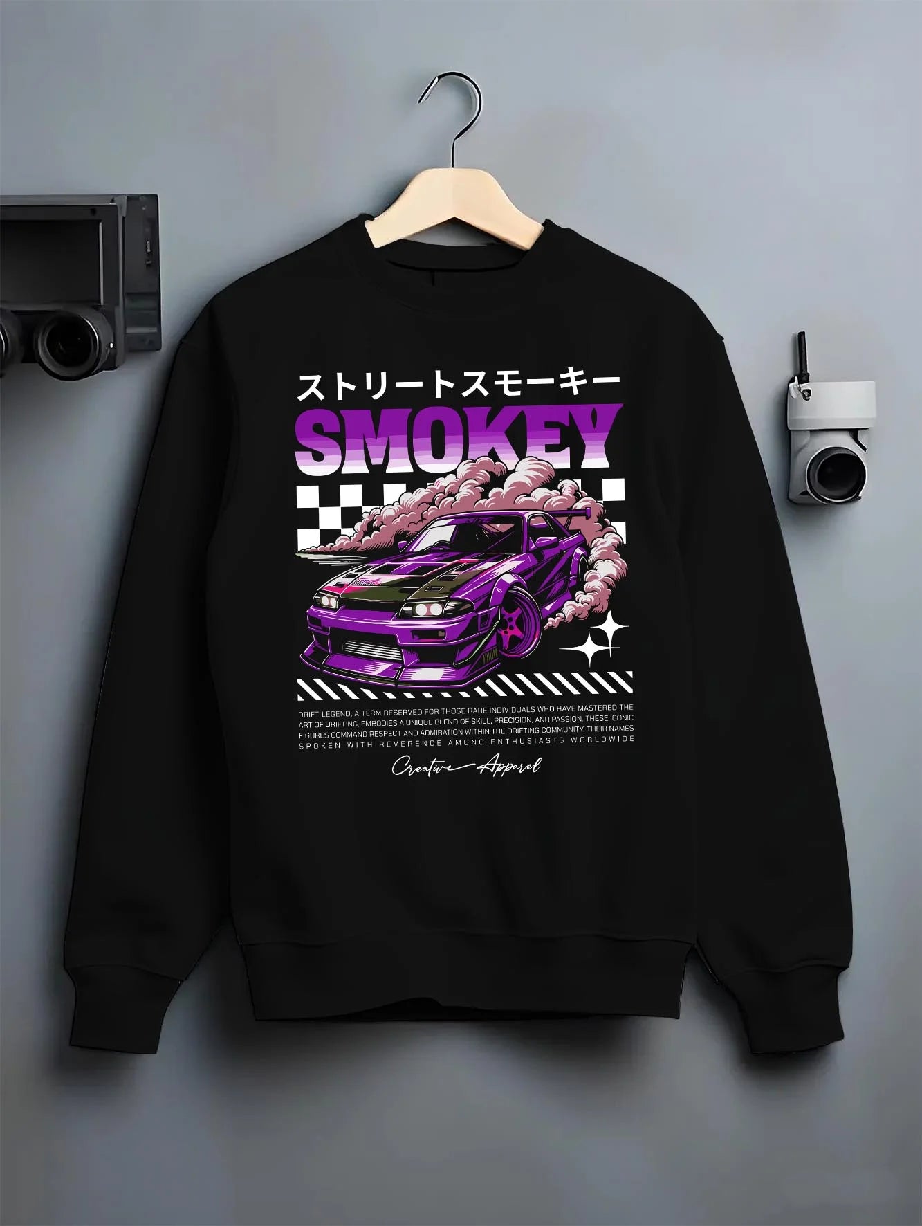 Black crewneck sweatshirt on a hanger against a grey wall, featuring racing drift muscle street retro classic performance graphic.