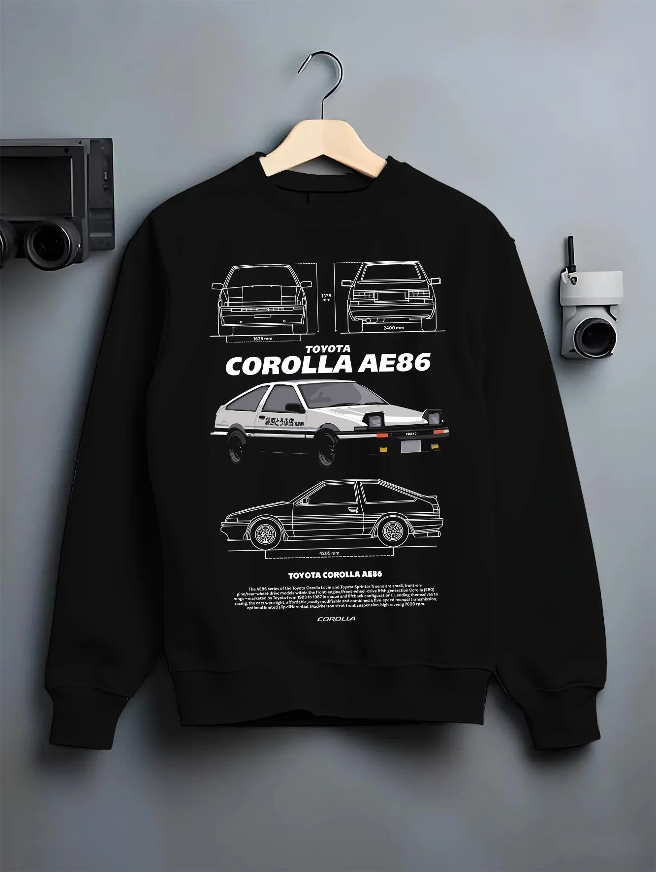 Black crewneck sweatshirt on a hanger against a grey wall, featuring Toyota AE86 drift legend racing street performance graphic.