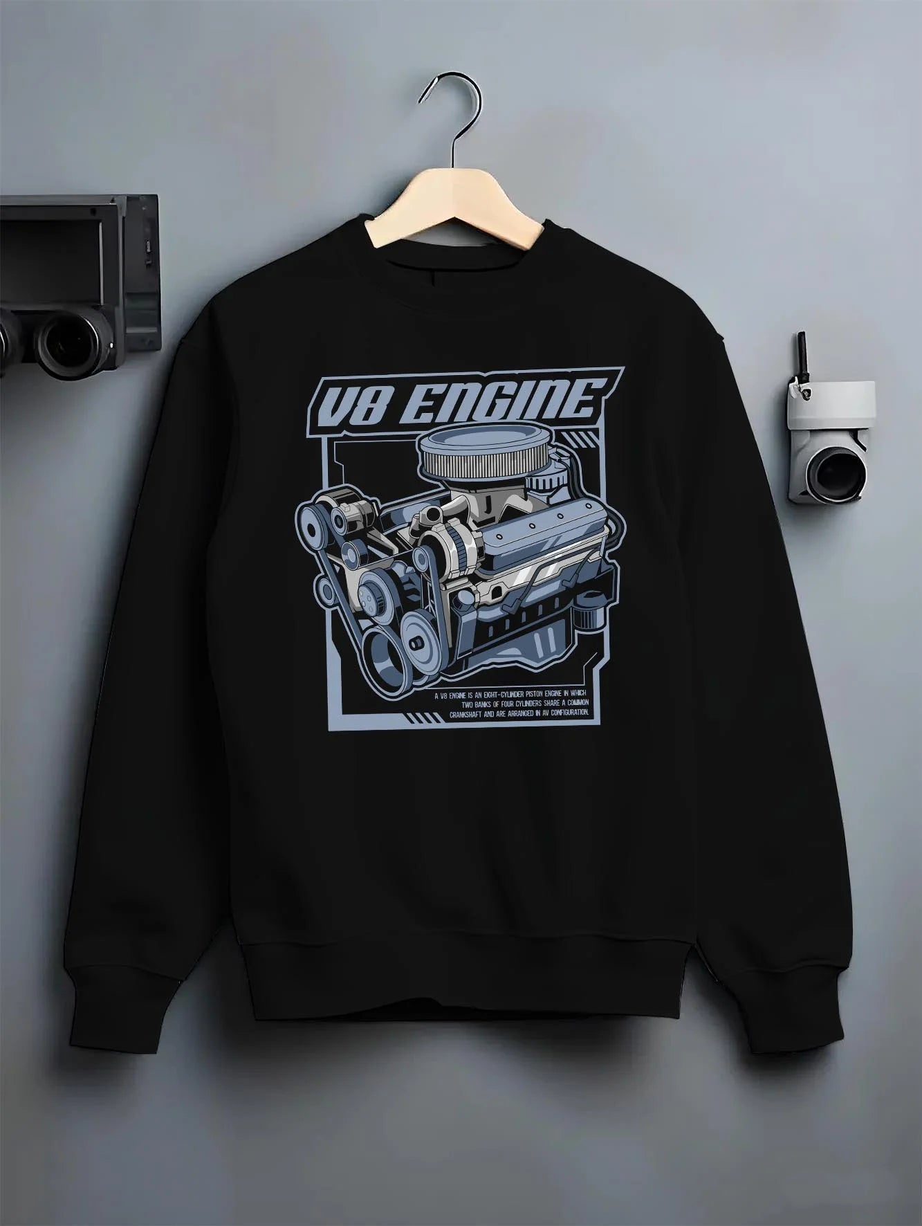 Black crewneck sweatshirt on a hanger against a grey wall, featuring rs v8 muscle street racing performance motorsport graphic.