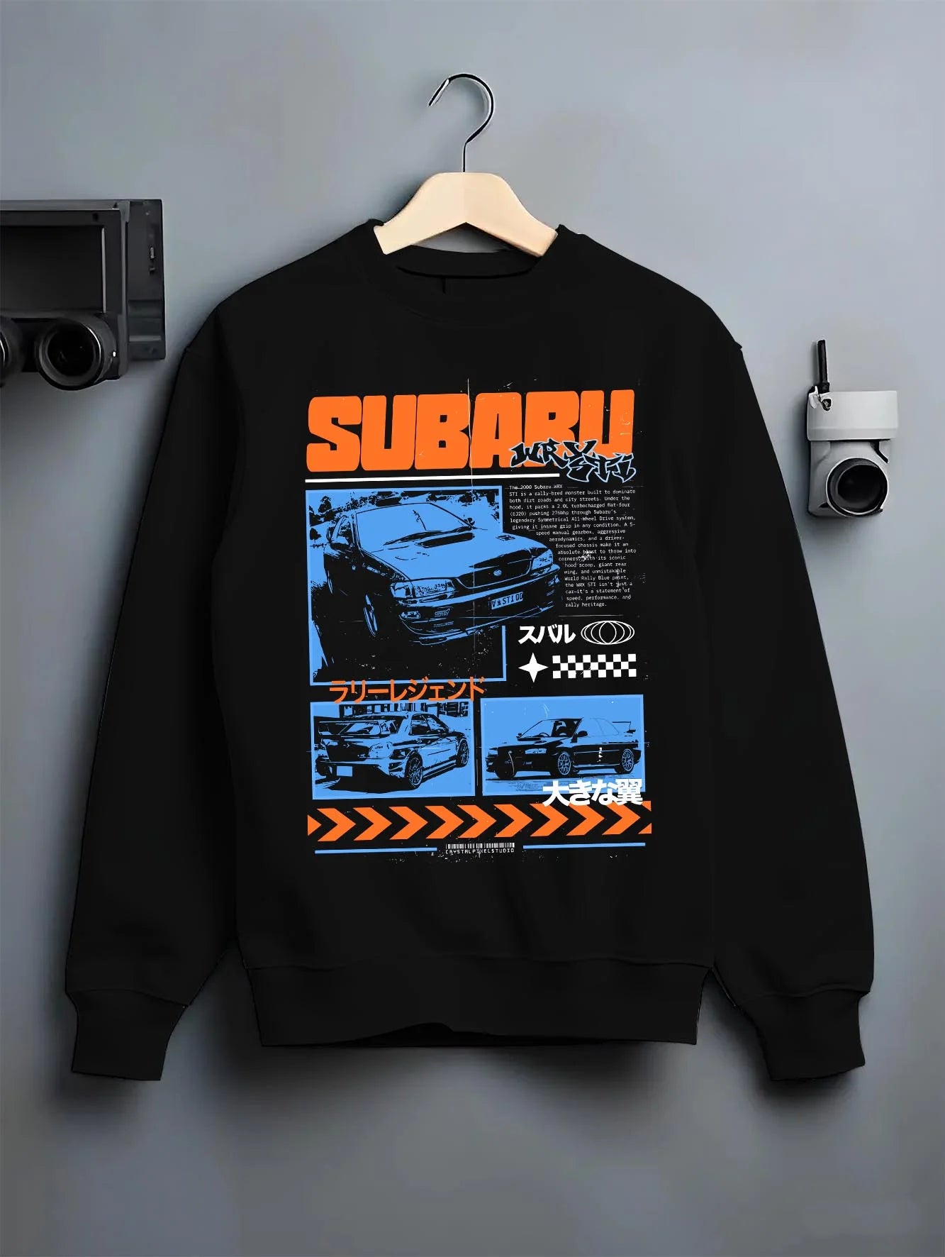 Black crewneck sweatshirt on a hanger against a grey wall, featuring Subaru WRX STI sti wrx turbo racing drift rally jdm graphic.
