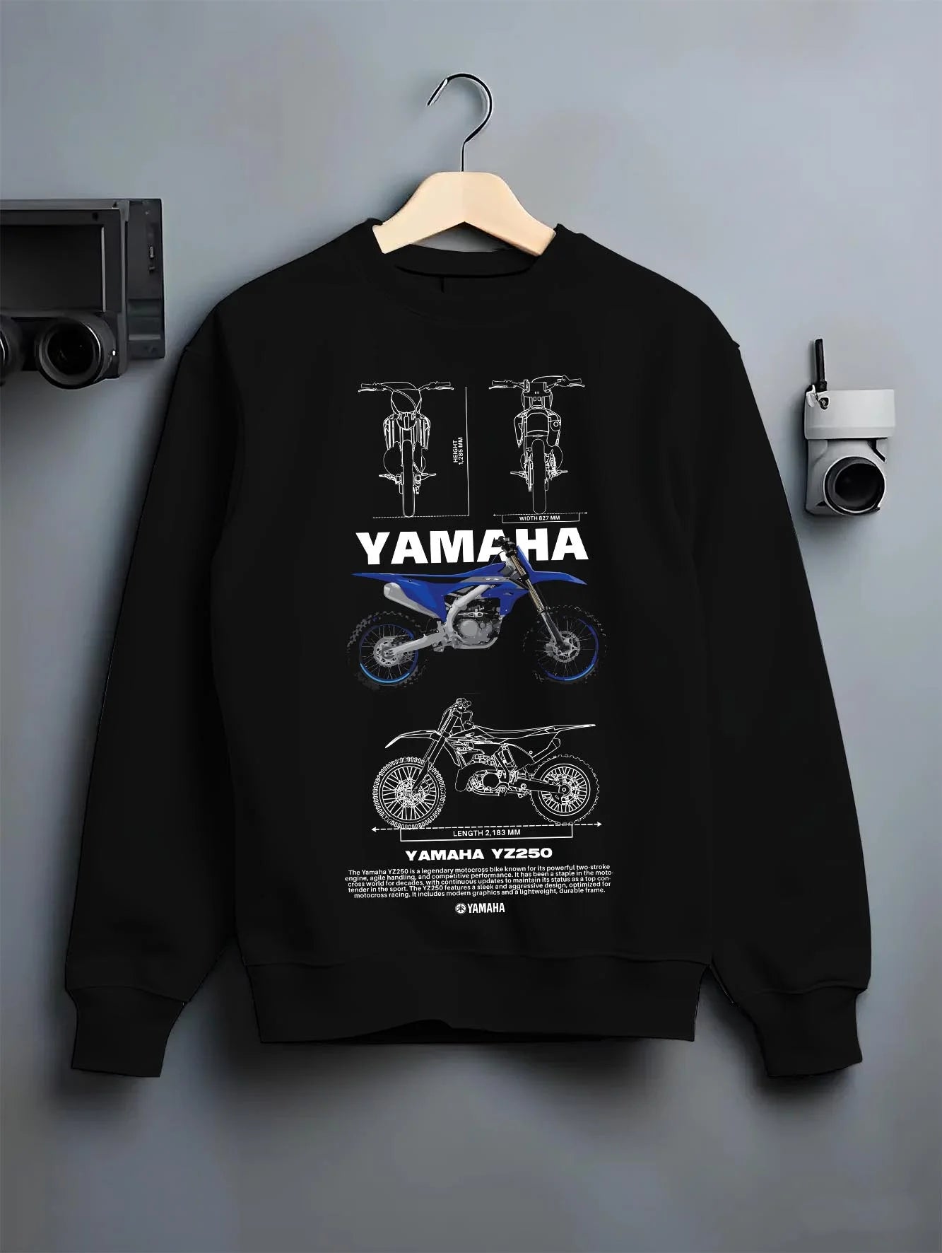Black crewneck sweatshirt on a hanger against a grey wall, featuring Yamaha YZ250 racing street enthusiast performance graphic.