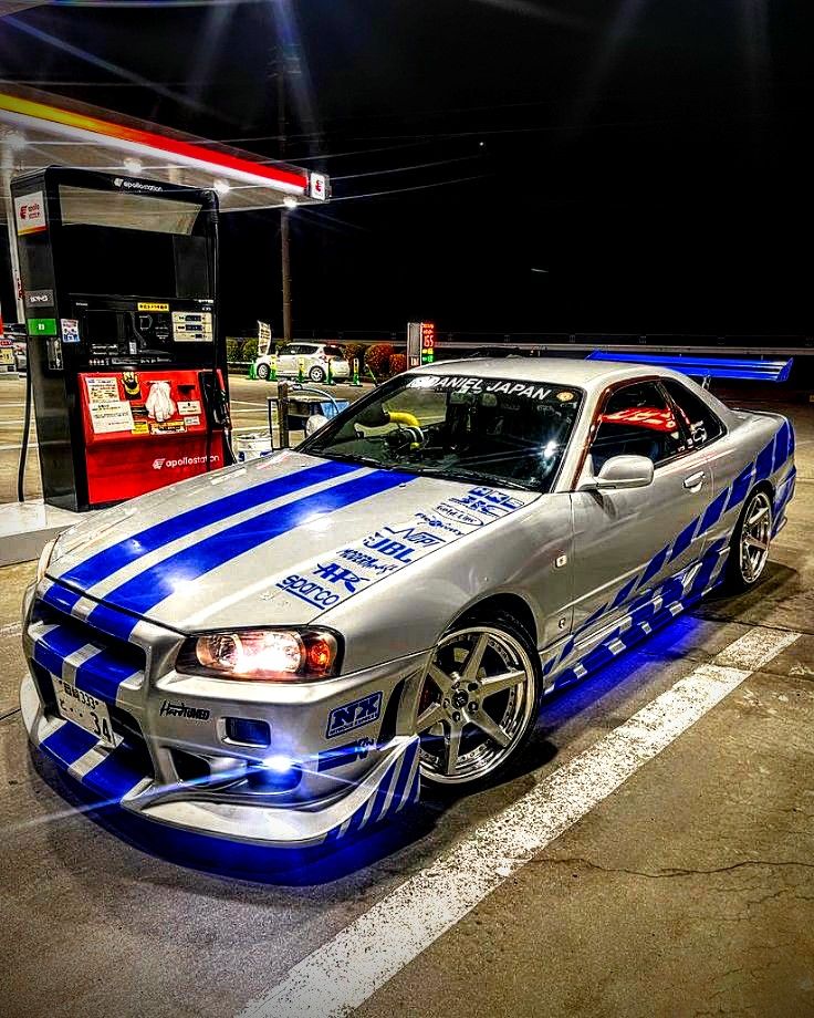 Trackhead JDM Nissan Skyline R34 with blue racing livery at night, street racing inspired car culture