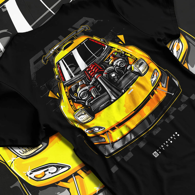 Black T-shirt featuring yellow Mazda RX-7 rotary engine graphic in bold JDM tuner streetwear design with drift-inspired artwork.