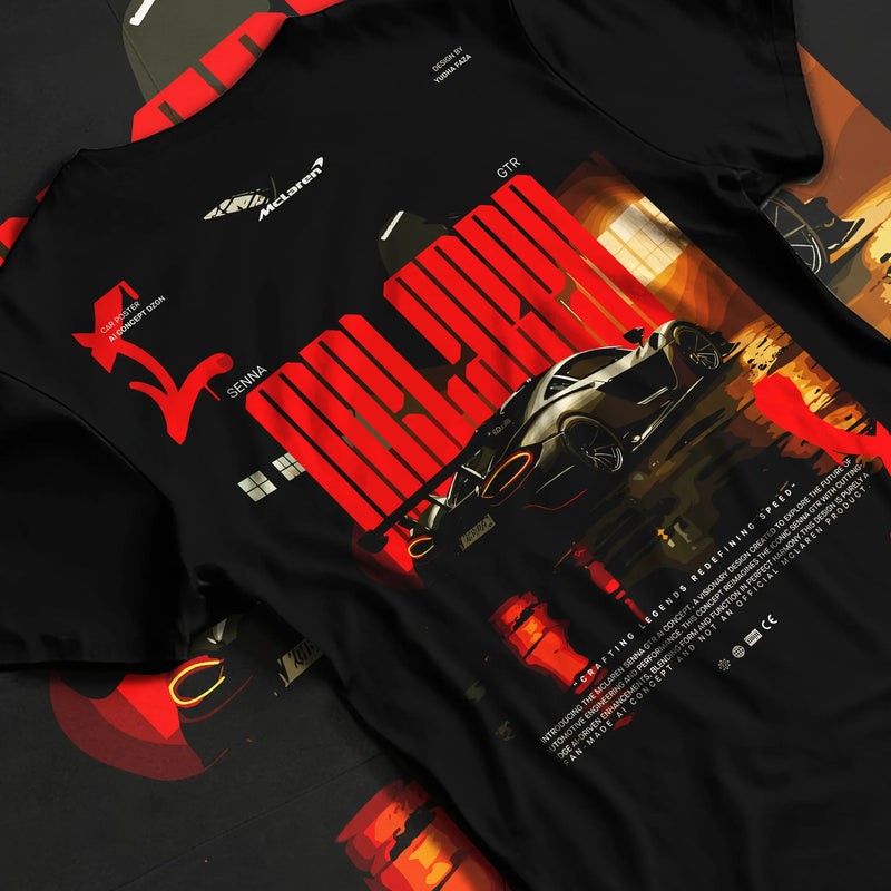 Black T-shirt featuring McLaren supercar graphic in bold orange performance streetwear design with racing-inspired artwork.