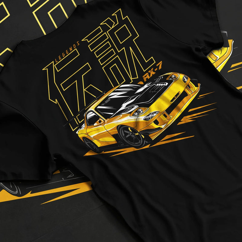 Black T-shirt featuring yellow Mazda RX-7 JDM legend graphic in bold street-racing design with Japanese text artwork.