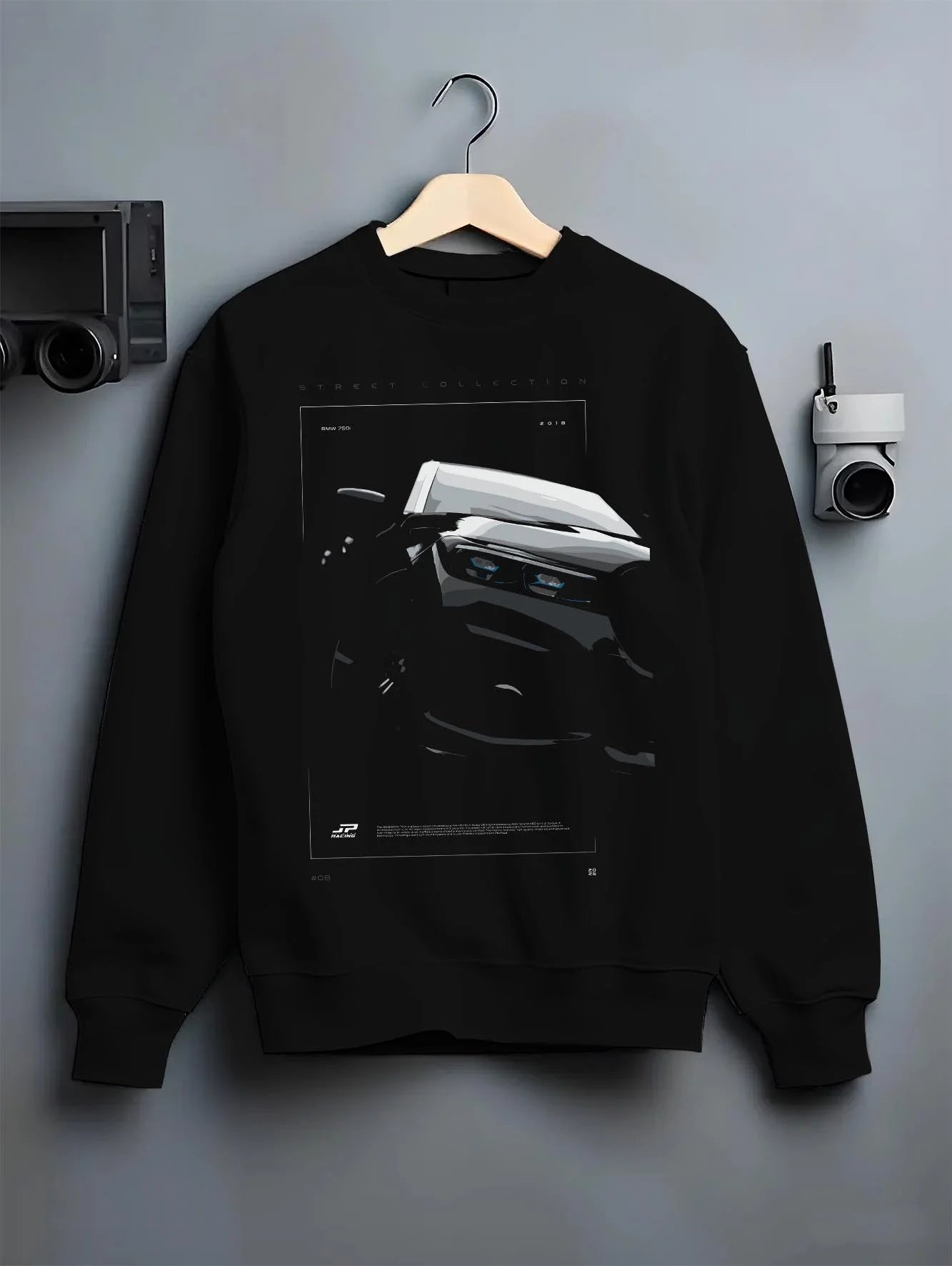 Black crewneck sweatshirt on a hanger against a grey wall, featuring BMW 750I rs turbo motorsport euro german street graphic.