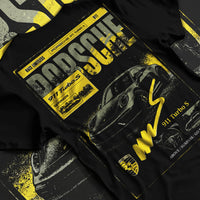 Black T-shirt laid flat with natural fabric folds, featuring Porsche 911 Turbo S rs 911 turbo racing german street classic graphic.