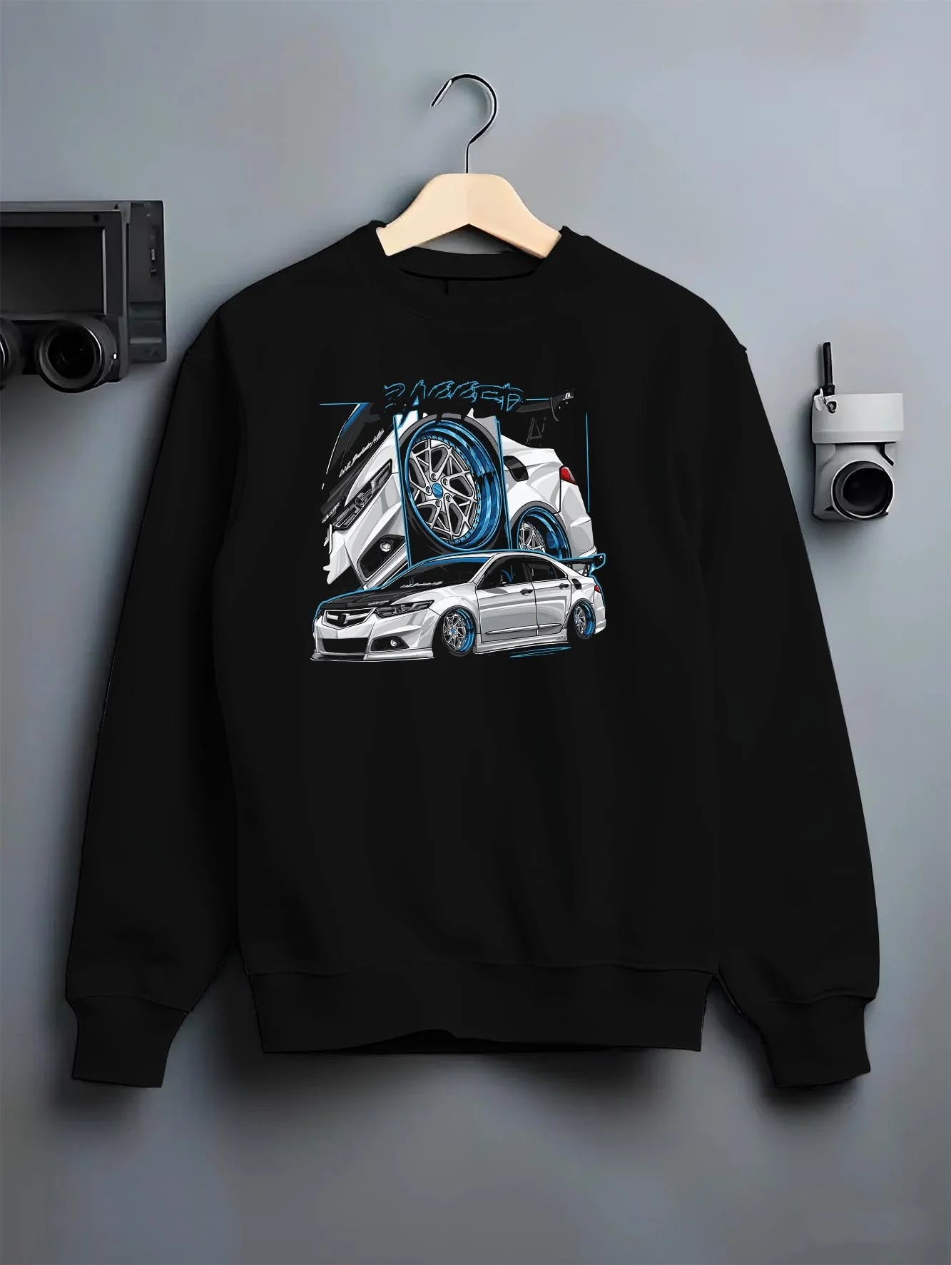 Black crewneck sweatshirt on a hanger against a grey wall, featuring ACURA jdm tuning stance slammed bagged street graphic.