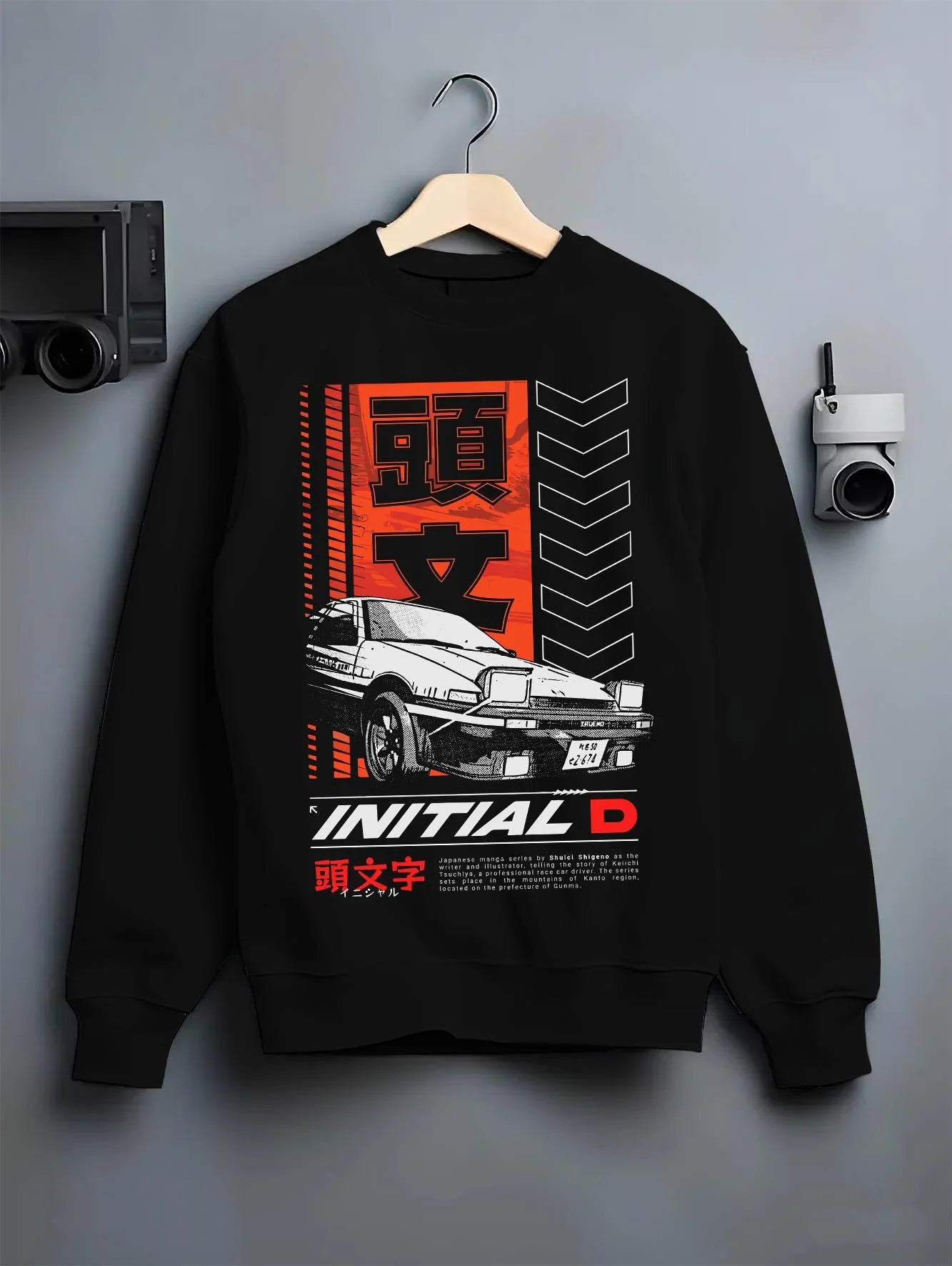 Black crewneck sweatshirt on a hanger against a grey wall, featuring AE86 racing drift jdm japanese initial d street legend graphic.