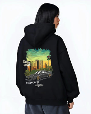 Black hoodie worn by a female model, back view, featuring Dodge Charger skyline american muscle street classic racing graphic.