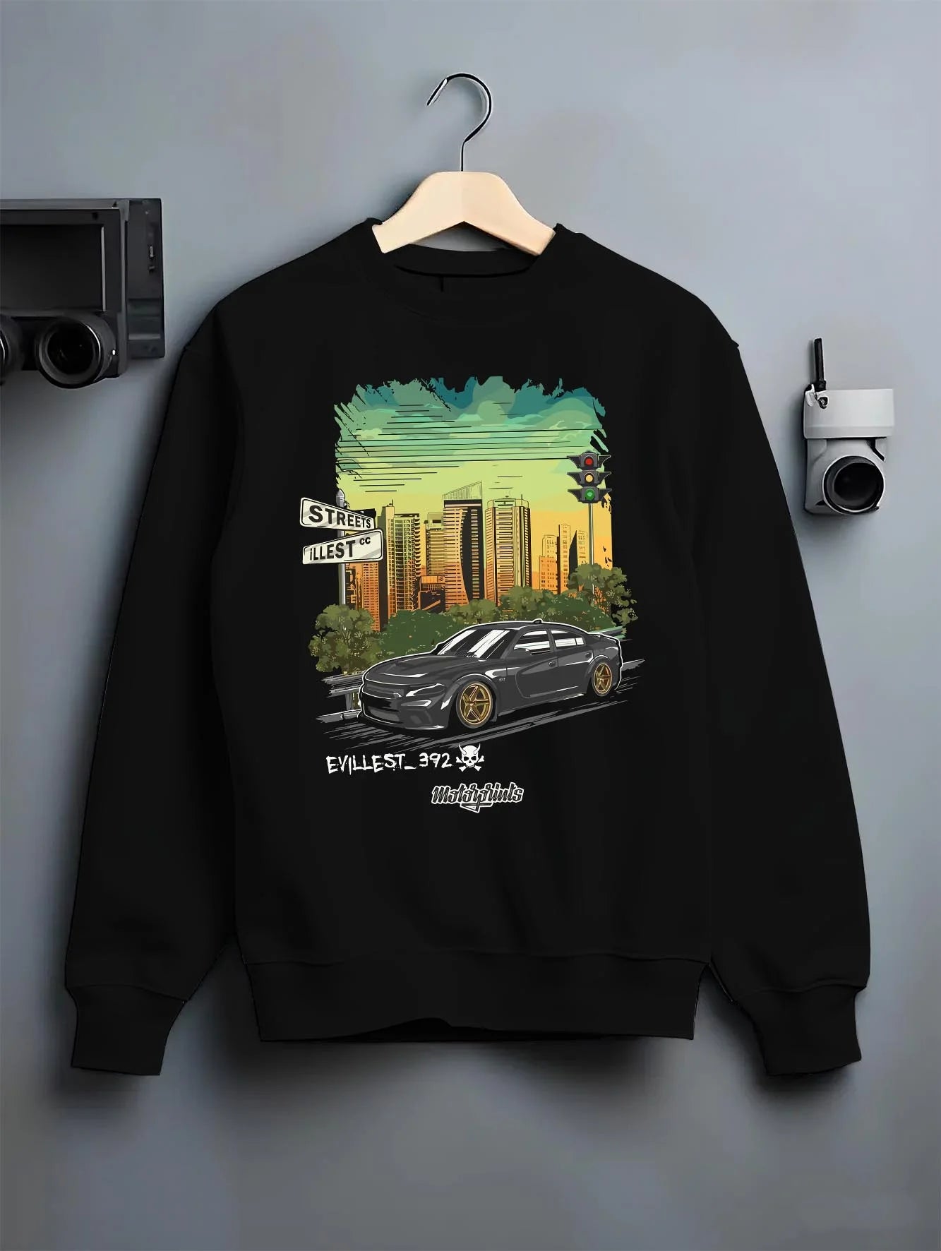 Black crewneck sweatshirt on a hanger against a grey wall, featuring Dodge Charger skyline american muscle street classic graphic.
