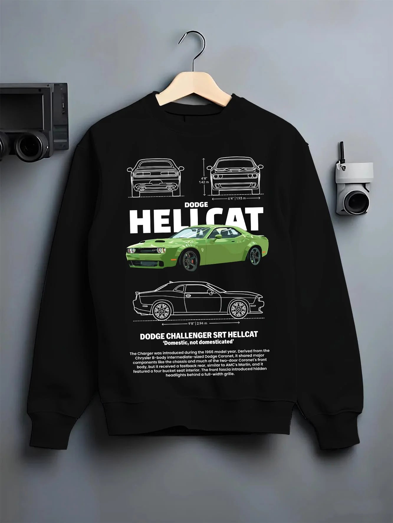 Black crewneck sweatshirt on a hanger against a grey wall, featuring Dodge Hellcat srt challenger muscle street racing graphic.