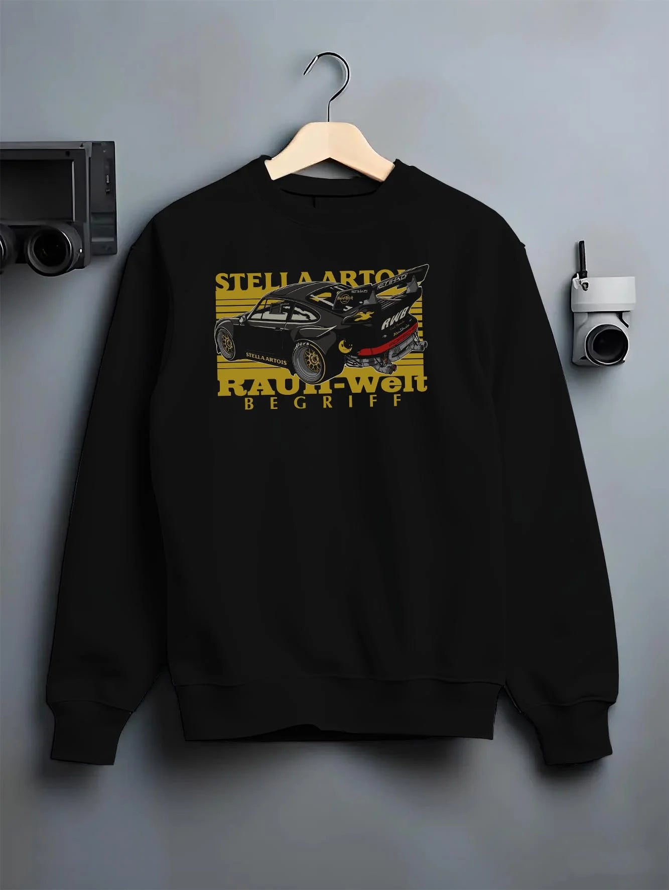 Black crewneck sweatshirt on a hanger against a grey wall, featuring Porsche 911 rs racing jdm stance widebody rwb street graphic.