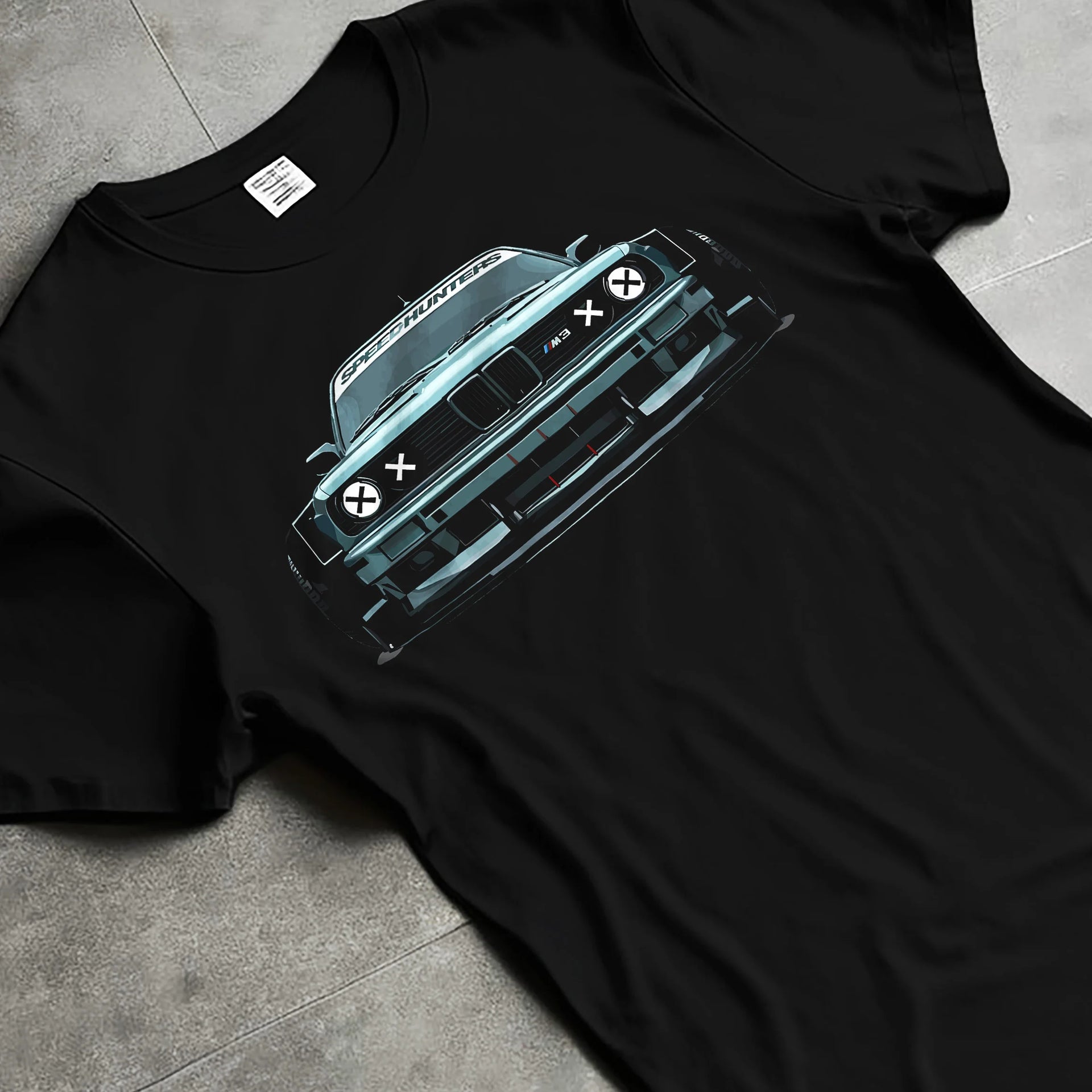 Black T-shirt laid flat with natural fabric folds, featuring BMW M3 rs drift classic racing street performance graphic.
