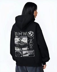 Black hoodie worn by a female model, back view, featuring BMW M4 german racing street performance motorsport automotive graphic.
