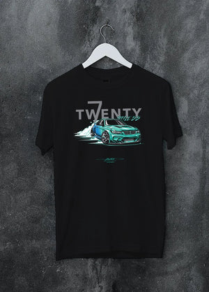 Black crewneck T-shirt on a hanger against a grey wall, featuring BMW turbo drift racing street performance motorsport graphic.