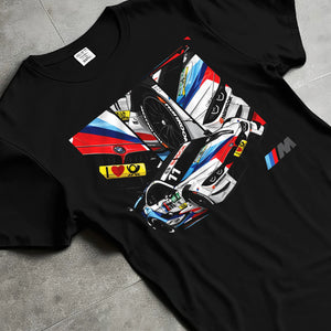 Black T-shirt laid flat with natural fabric folds, featuring BMW M4 rs racing motorsport street performance automotive graphic.