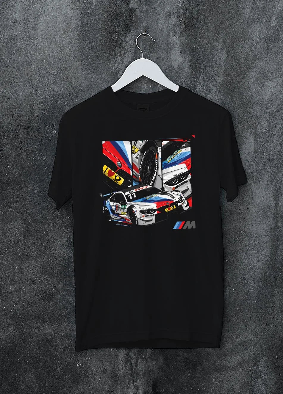 Black crewneck T-shirt on a hanger against a grey wall, featuring BMW M4 rs racing motorsport street performance automotive graphic.