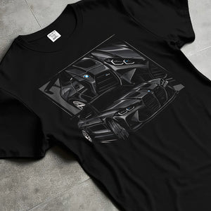 Black T-shirt laid flat with natural fabric folds, featuring BMW M4 german tuner street racing performance motorsport graphic.