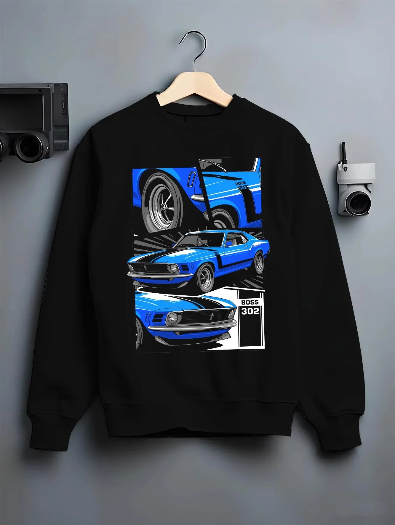 Black crewneck sweatshirt on a hanger against a grey wall, featuring Ford Mustang Boss 302 boss 302 mustang muscle classic graphic.
