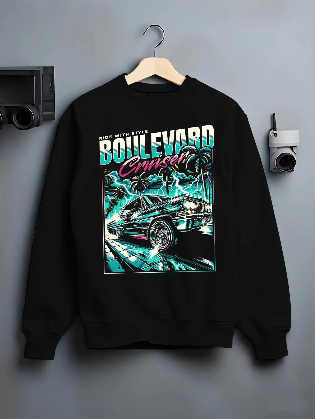 Black crewneck sweatshirt on a hanger against a grey wall, featuring street racing performance motorsport automotive graphic.