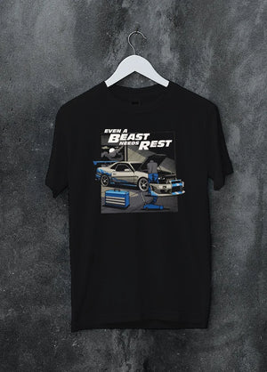 Black crewneck T-shirt on a hanger against a grey wall, featuring racing tuner street retro beast performance motorsport graphic.