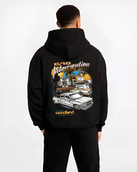 Black hoodie worn by a male model, back view, featuring Chevrolet C10 retro vintage classic racing street performance graphic.