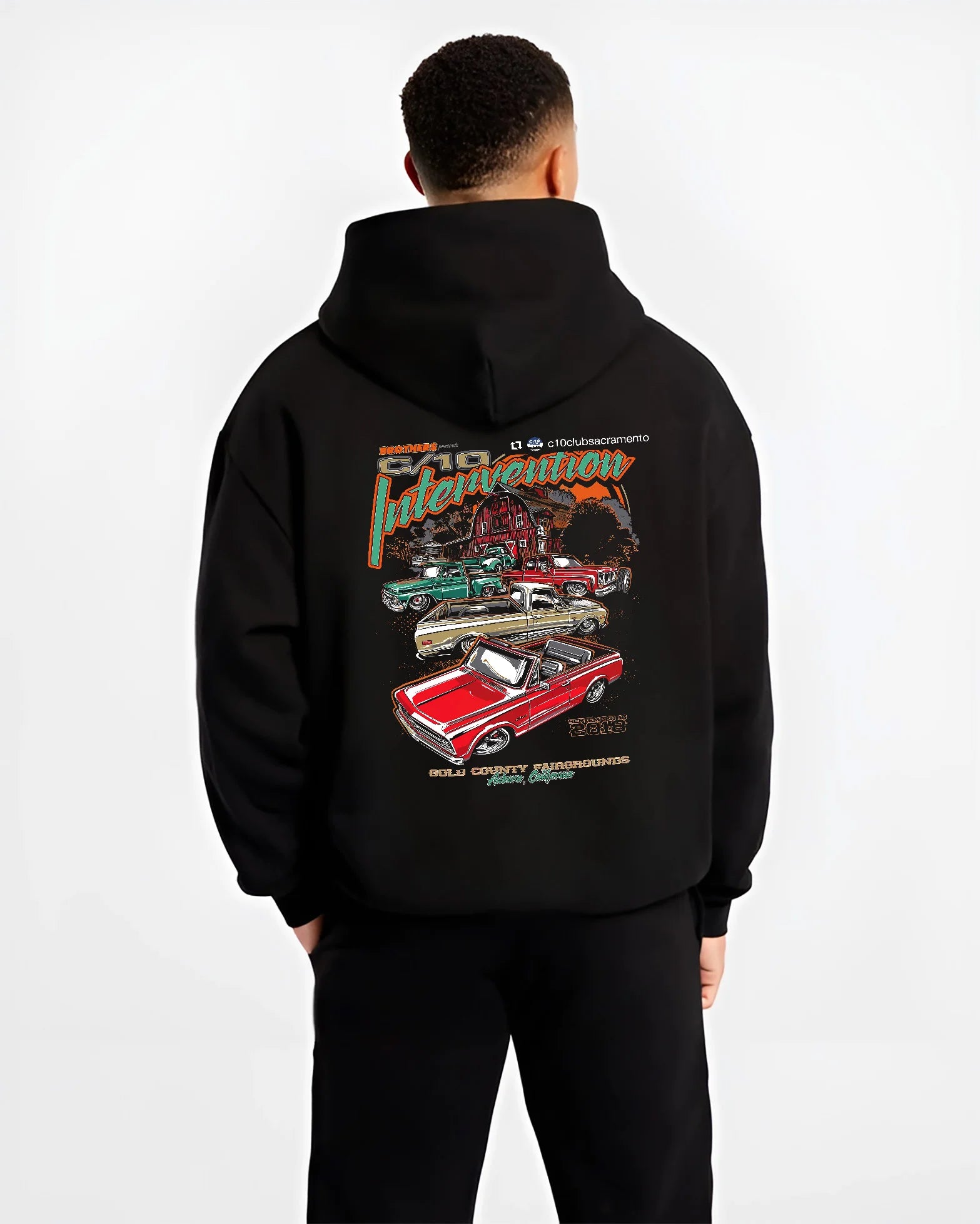 Black hoodie worn by a male model, back view, featuring Chevrolet C10 vintage classic enthusiast meet racing street graphic.