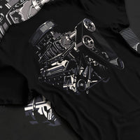 Black T-shirt laid flat with natural fabric folds, featuring street enthusiast racing performance motorsport automotive graphic.