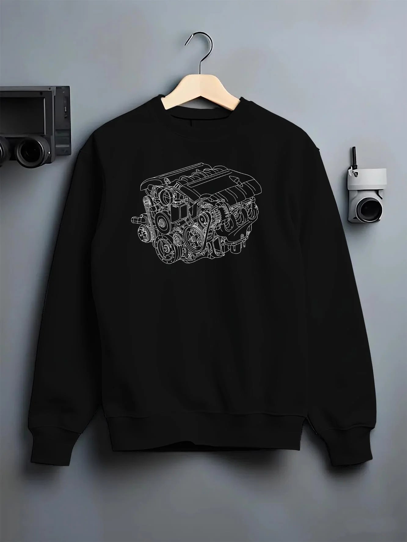 Black crewneck sweatshirt on a hanger against a grey wall, featuring street enthusiast racing performance motorsport ceng4.