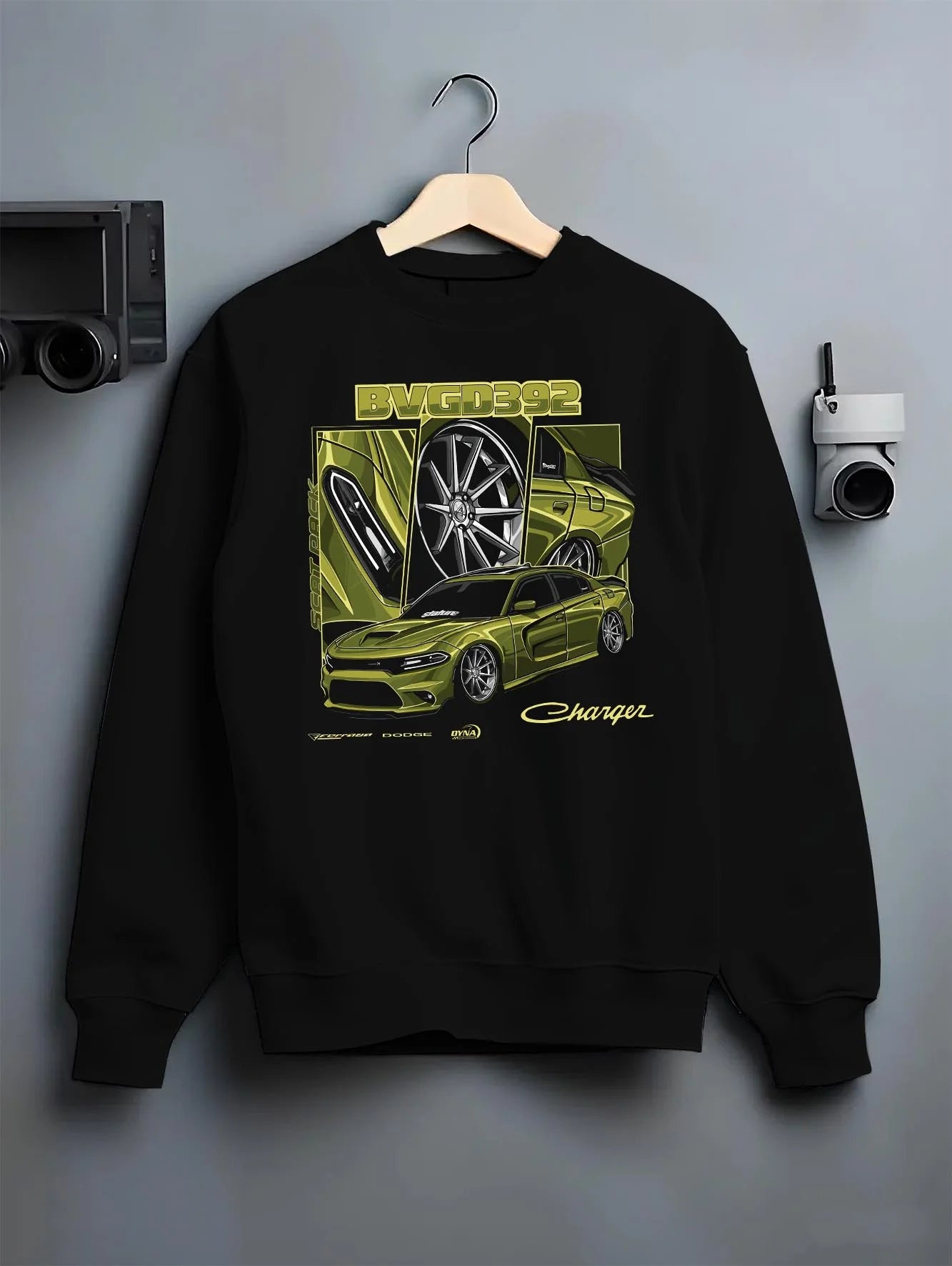 Black crewneck sweatshirt on a hanger against a grey wall, featuring Dodge Charger racing jdm american muscle street retro graphic.