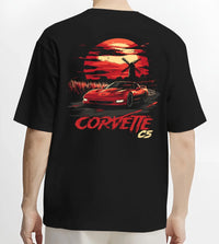 Black T-shirt worn by a male model, back view, featuring Chevrolet Camaro racing drag american muscle street retro vintage graphic.