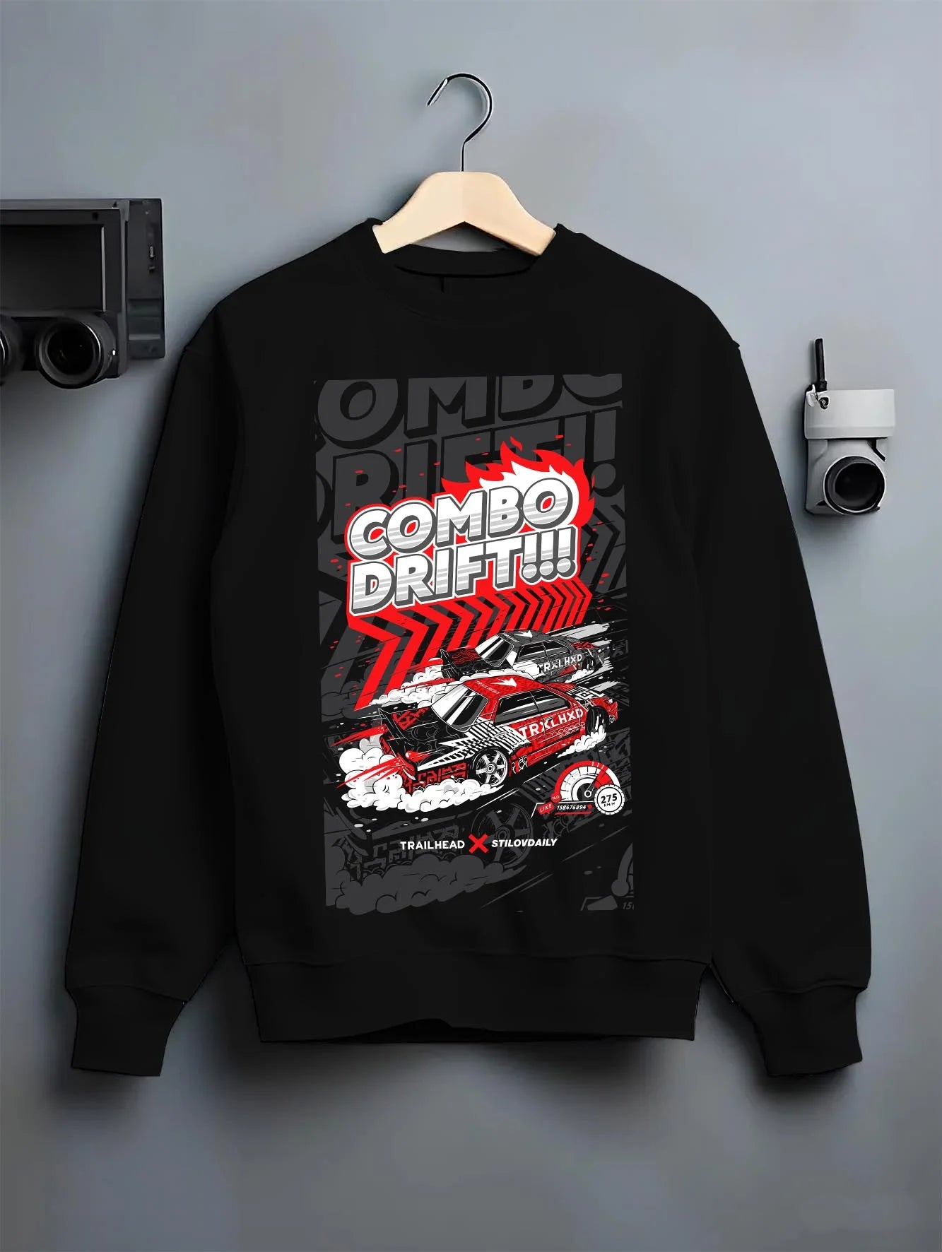 Black crewneck sweatshirt on a hanger against a grey wall, featuring racing drift jdm street performance motorsport graphic.