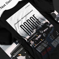 Black T-shirt laid flat with natural fabric folds, featuring Dodge Challenger american muscle street retro classic legend graphic.