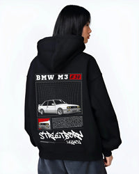 Black hoodie worn by a female model, back view, featuring BMW rs turbo racing drift motorsport euro street retro classic graphic.