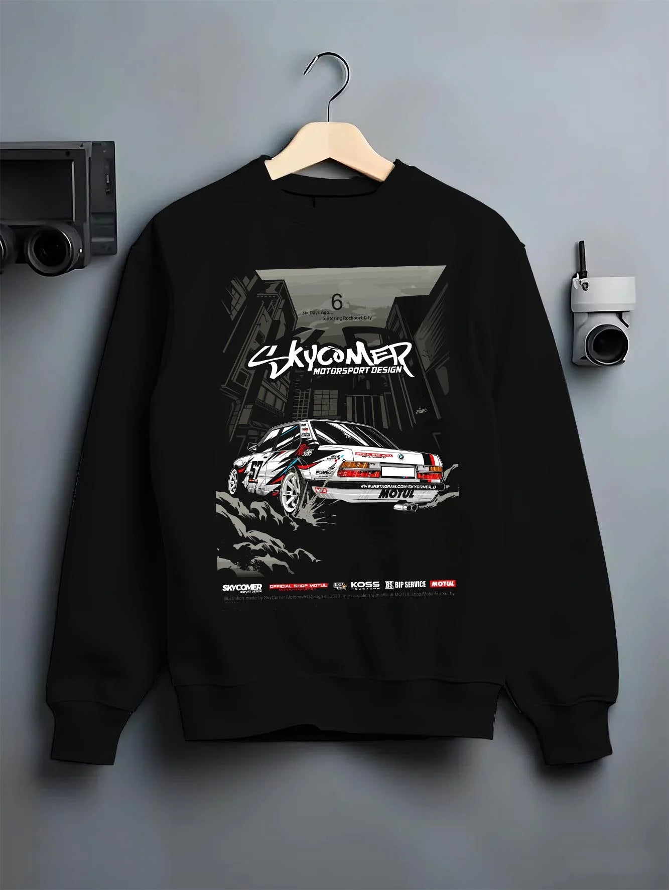 Black crewneck sweatshirt on a hanger against a grey wall, featuring BMW rs turbo racing drift motorsport euro german e28s5r.