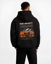 Black hoodie worn by a male model, back view, featuring BMW E30 rs motorsport street vintage classic racing graphic.