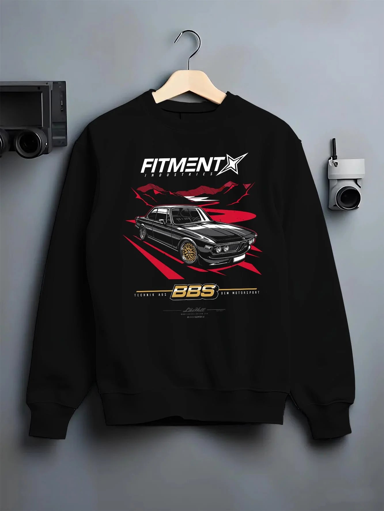 Black crewneck sweatshirt on a hanger against a grey wall, featuring BMW rs turbo ls racing motorsport euro street retro graphic.