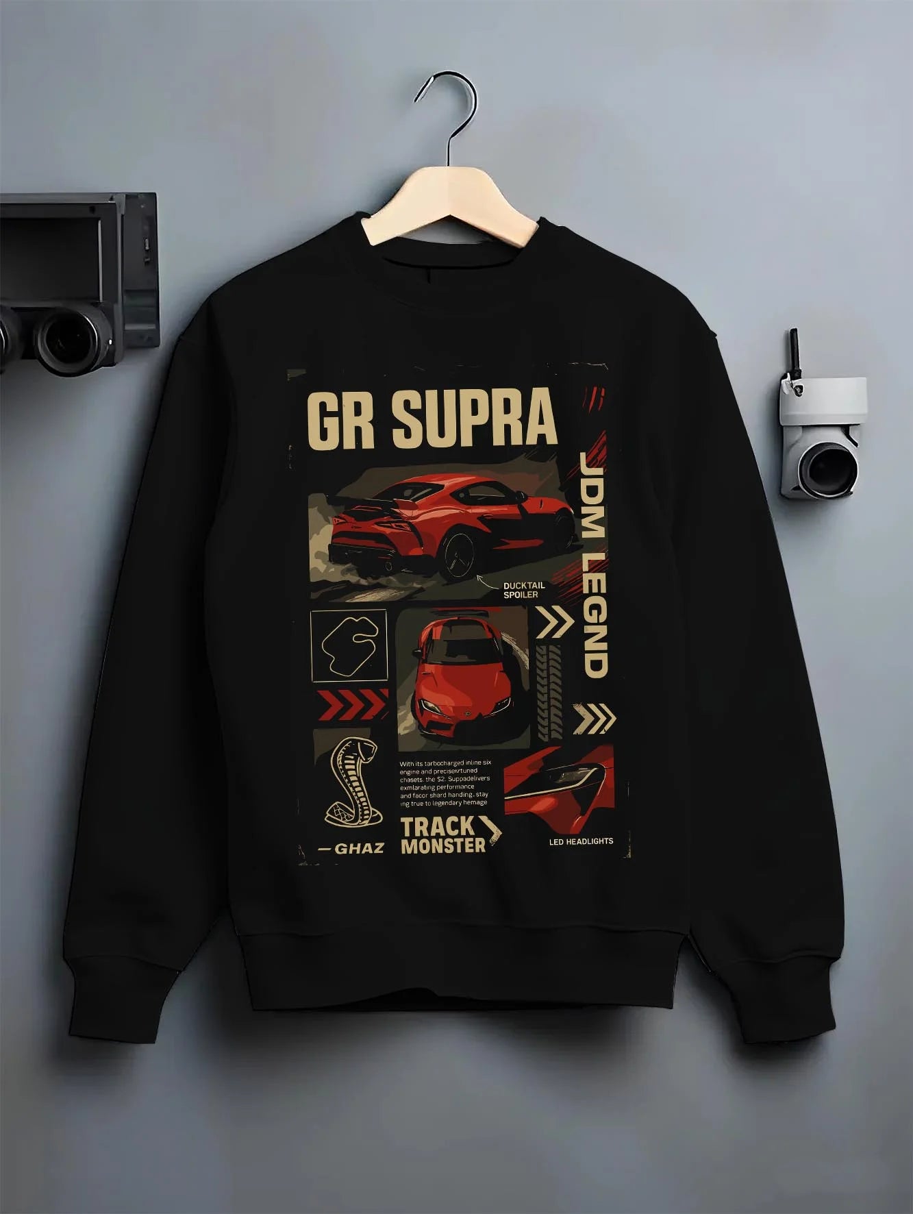 Black crewneck sweatshirt on a hanger against a grey wall, featuring SUPRA turbo turbocharged racing drift jdm japanese graphic.