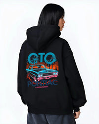 Black hoodie worn by a female model, back view, featuring Pontiac GTO muscle street retro vintage classic enthusiast graphic.