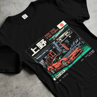 Black T-shirt laid flat with natural fabric folds, featuring Honda rs racing motorsport street retro classic speed graphic.