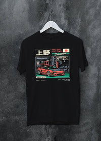 Black crewneck T-shirt on a hanger against a grey wall, featuring Honda rs racing motorsport street retro classic speed graphic.