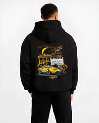 Black hoodie worn by a male model, back view, featuring racing street retro performance motorsport automotive enthusiast graphic.