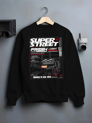 Black crewneck sweatshirt on a hanger against a grey wall, featuring Toyota JZX100 turbo drift street racing performance graphic.