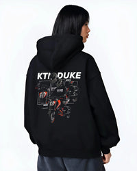 Black hoodie worn by a female model, back view, featuring KTM rs racing street performance motorsport automotive enthusiast graphic.