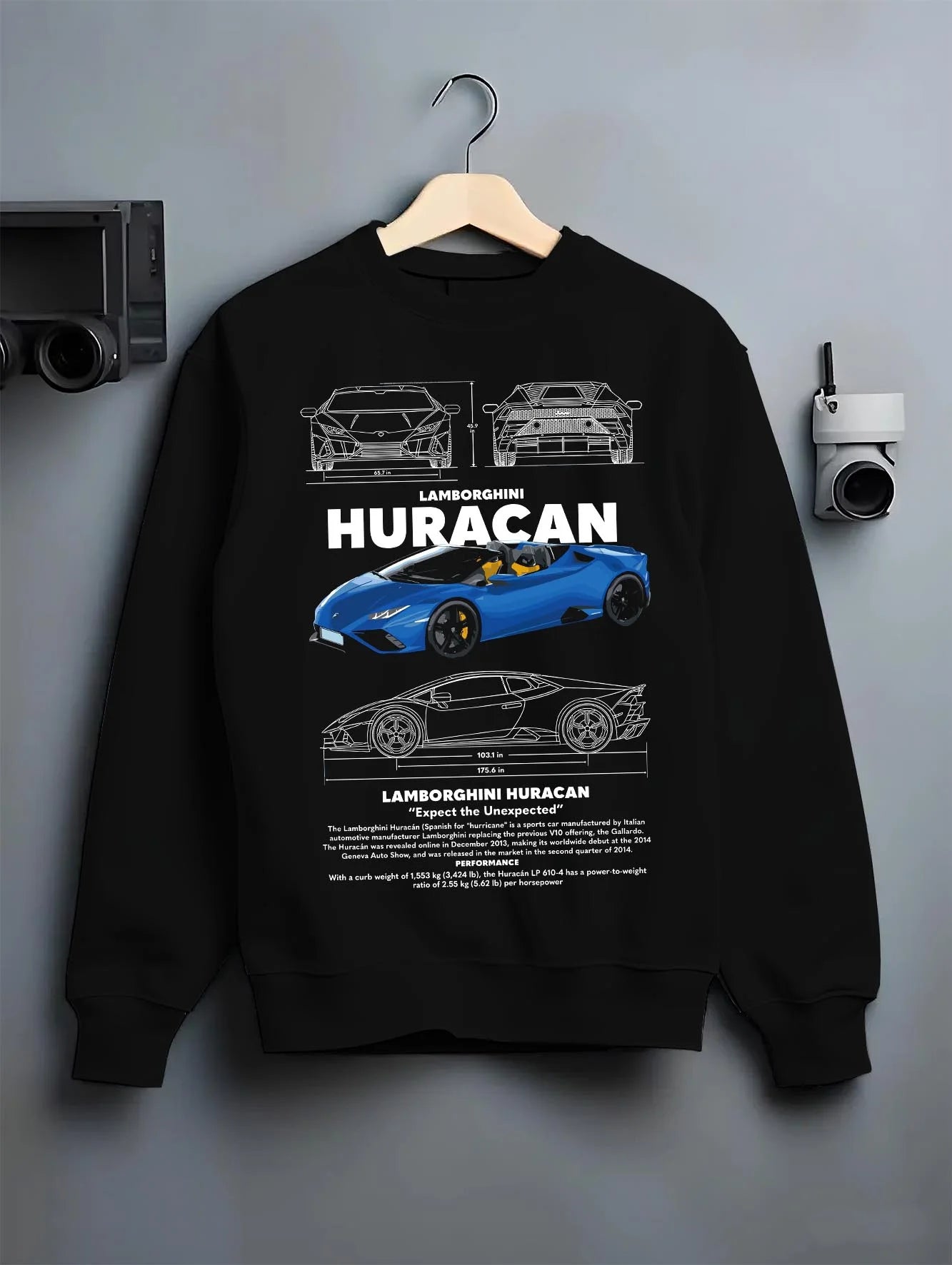 Black crewneck sweatshirt on a hanger against a grey wall, featuring SKYLINE racing street performance motorsport graphic.